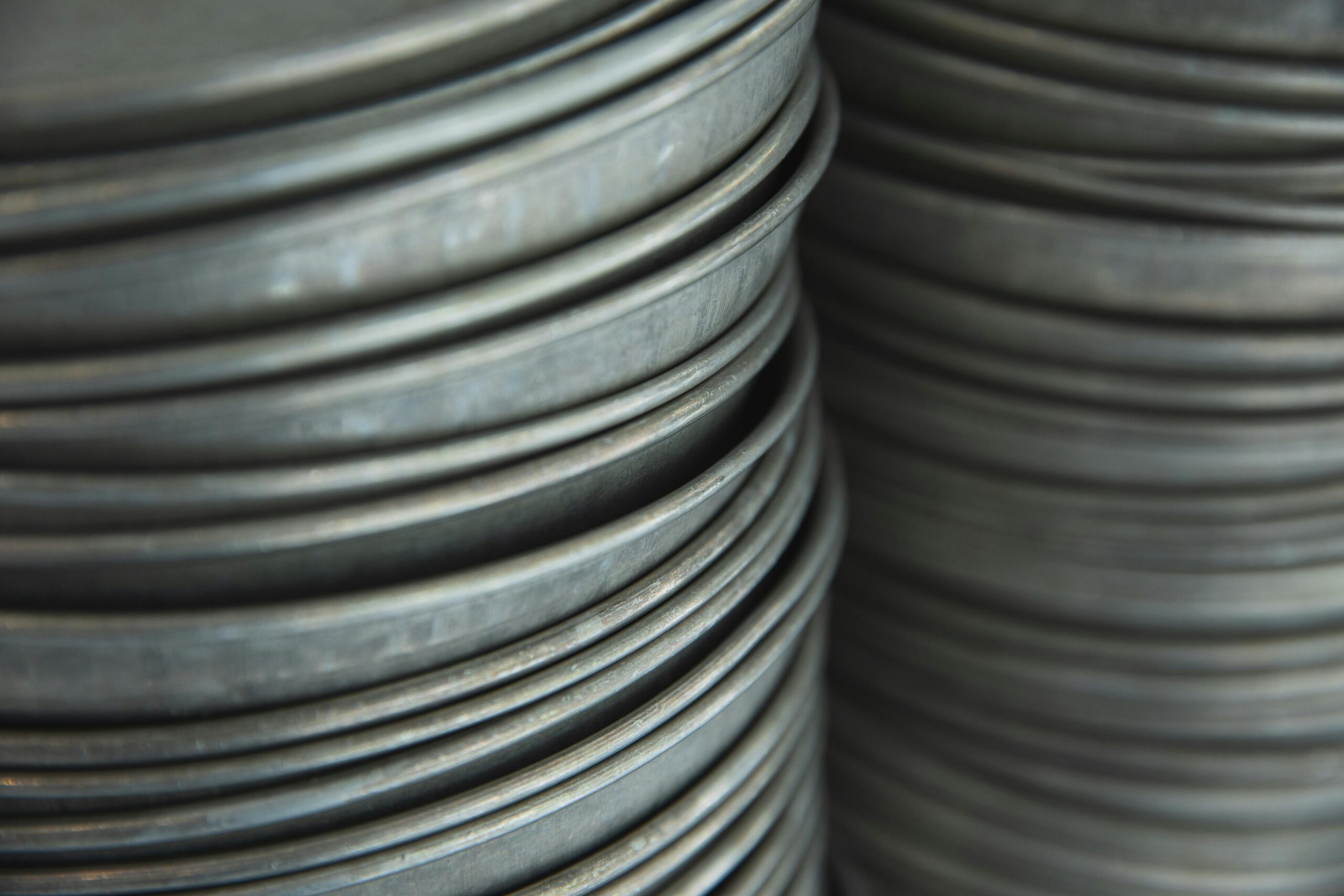 Clean metal round baking sheets placed in rows in light kitchen in daytime